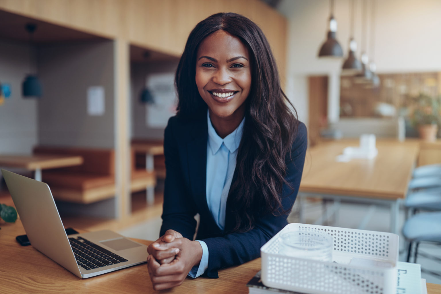 Smiling young African American businesswoman working in an offic ...